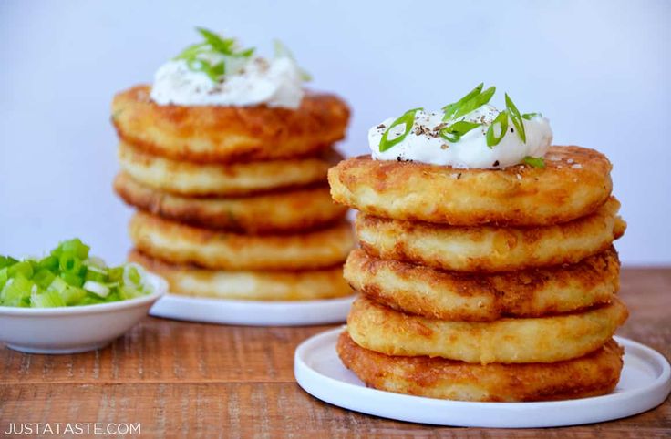 a stack of pancakes sitting on top of a white plate next to a bowl of lettuce