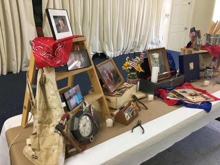 a table with pictures and other items on it, including an american flag banner in the background