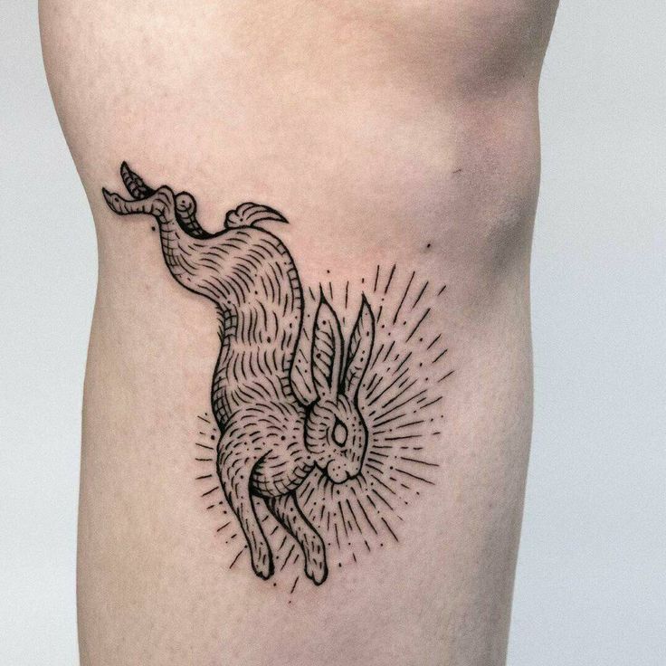 a black and white tattoo of a rabbit