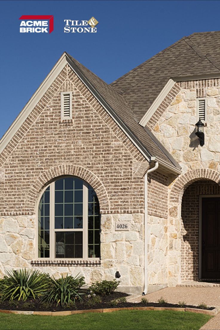 a brick and stone house with large windows