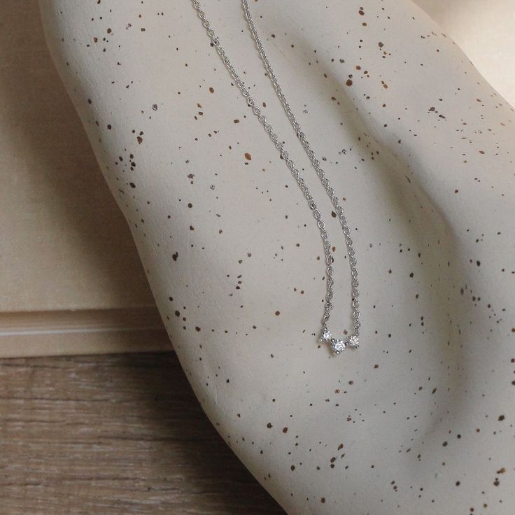 This beautiful trio of white diamonds stuns in it’s constellation like shape. A classic and elegant piece, any glamour lover craves to add the Frida to their necklace collection. This spectacular piece is perfect for any occasion and adds a statement to any look. All features can be customized! Please contact us if you wish to make changes, we love making custom designs. All of our jewelry is carefully handmade in our atelier. *HC diamond are all conflict-free diamonds To order by phone 972-72-2 Timeless Sterling Silver Necklace In Diamond White, Silver Diamond Necklace With Clavicle Chain For Everyday Luxury, Minimalist Cubic Zirconia Diamond Necklace For Everyday Luxury, Silver Three Stone Necklace In Fine Jewelry Style, Elegant Three Stone Sterling Silver Jewelry, Dainty Three Stone Cubic Zirconia Jewelry, Timeless Diamond Necklace With Sparkling Stones, Fine Jewelry Silver Necklace With Three Stones, Elegant Three-stone Diamond Jewelry