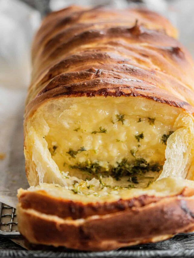 a loaf of bread with cheese and herbs on it