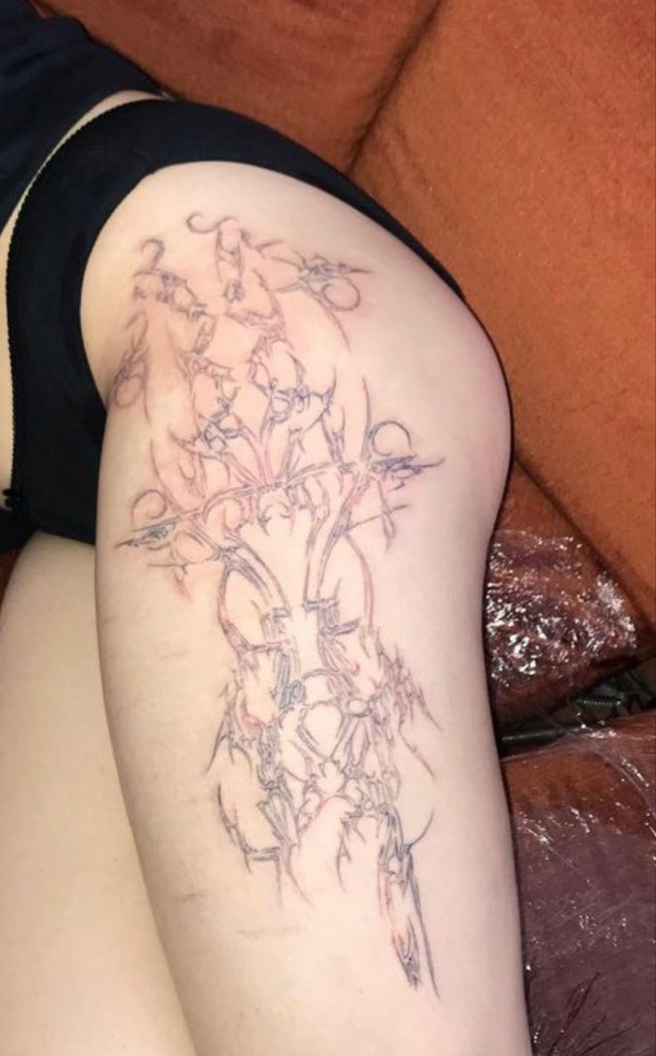 a woman's thigh with tattoos on her legs and the leg is covered in flowers