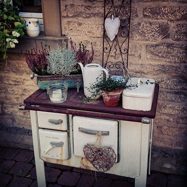 an old stove with pots and plants on top