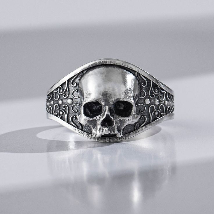 The jawless skull is an elegant, yet frighteningly beautiful design that gives this ring a sense of strength and power. It is truly a one of a kind piece that will be sure to get heads turning at every place you go. With this ring, you can turn heads anywhere and everywhere you go, whether you want to or not! This ring would be the perfect gift for any biker, punk rocker, goth or hippie in your life. Get your hands on this gorgeous silver gothic skull ring and show off your gothic side. It's als Gothic Silver Skull Ring, Symbolic Engraved Skull Ring, Gothic Skull Rings With Engraving, Halloween Skull Rings Symbolic Style, Symbolic Skull Rings For Halloween, Silver Skull Ring For Biker Events And Halloween, Vintage Black Skull Ring, Silver Engraved Skull Ring, Classic Skull Ring As Gift