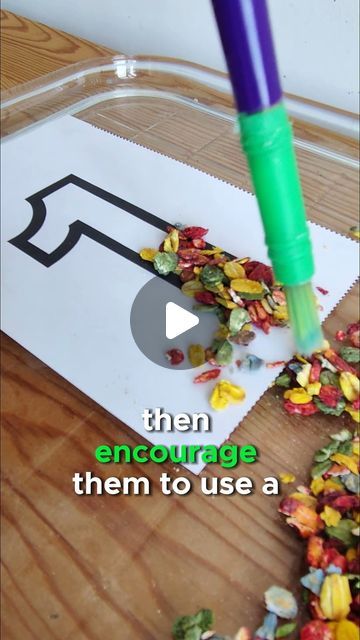 a purple and green pen sticking out of a piece of paper on top of a wooden table