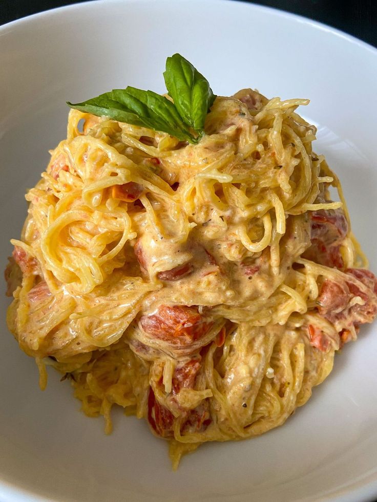 pasta with shrimp and tomato sauce in a white bowl on a black table top, ready to be eaten