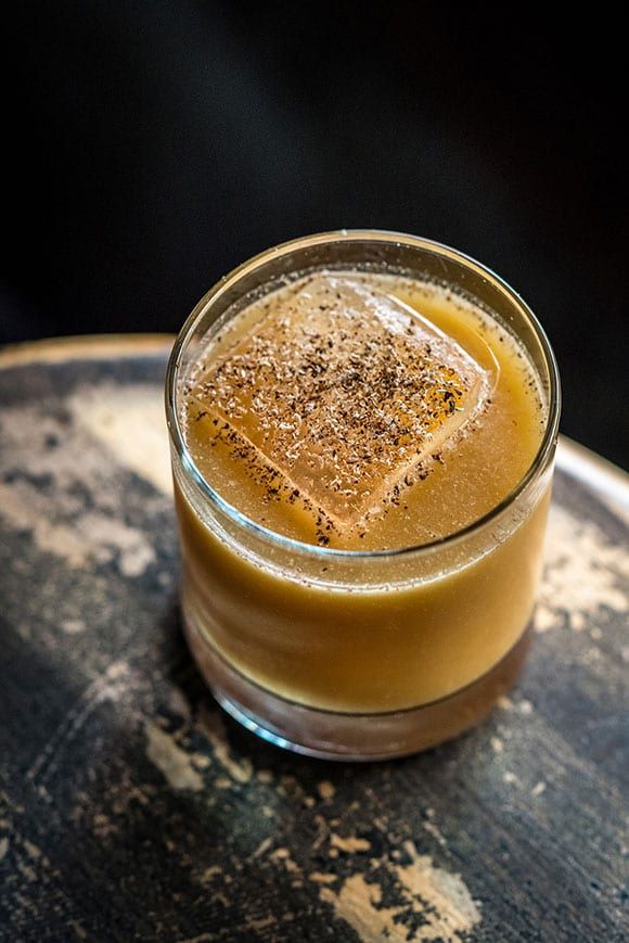 a glass filled with liquid sitting on top of a table