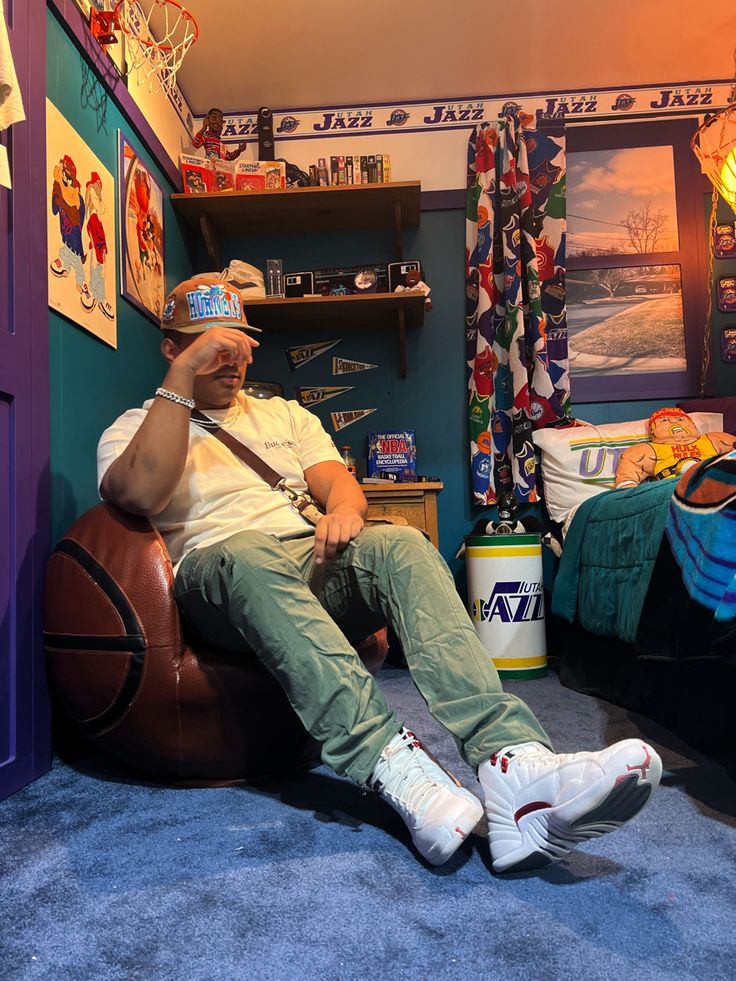 a man sitting on top of a brown chair in a room filled with posters and other items