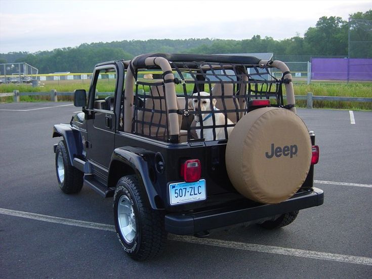 the jeep is parked in the parking lot with its luggage strapped to it's back