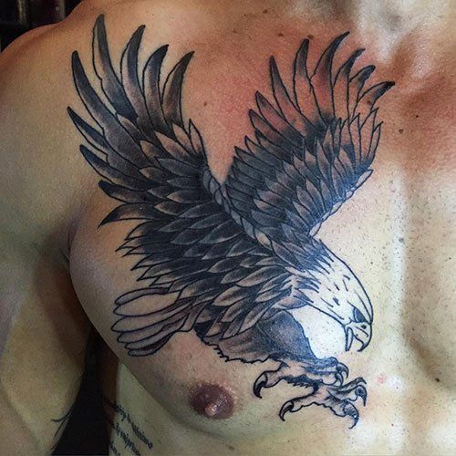 an eagle tattoo is on the chest of a man with no shirt and his arm