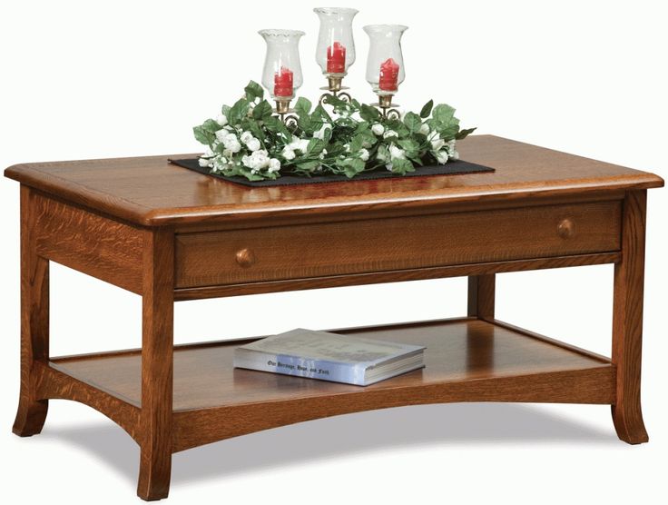 a coffee table with two candles on top and flowers in vases sitting on it