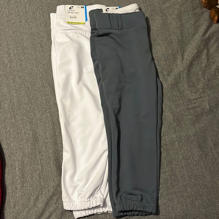 two men's pants laying on top of a bed