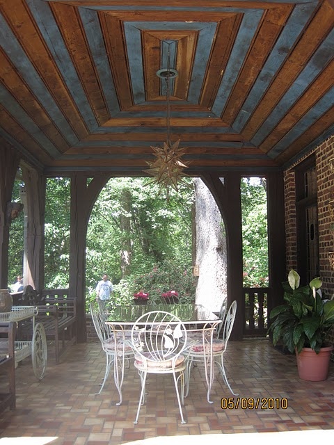 a covered patio area with tables and chairs