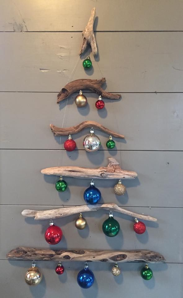 a christmas tree made out of driftwood with ornaments hanging from it's sides