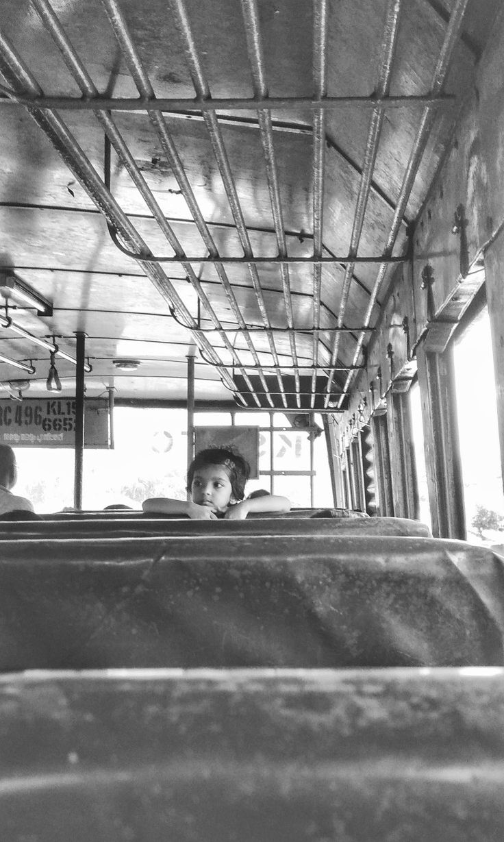 black and white photo of people in the back of a bus with metal bars on it