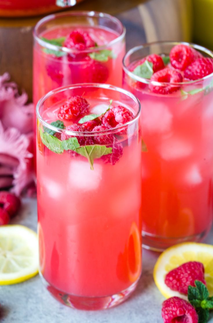 two glasses filled with raspberry lemonade and garnished with fresh mint