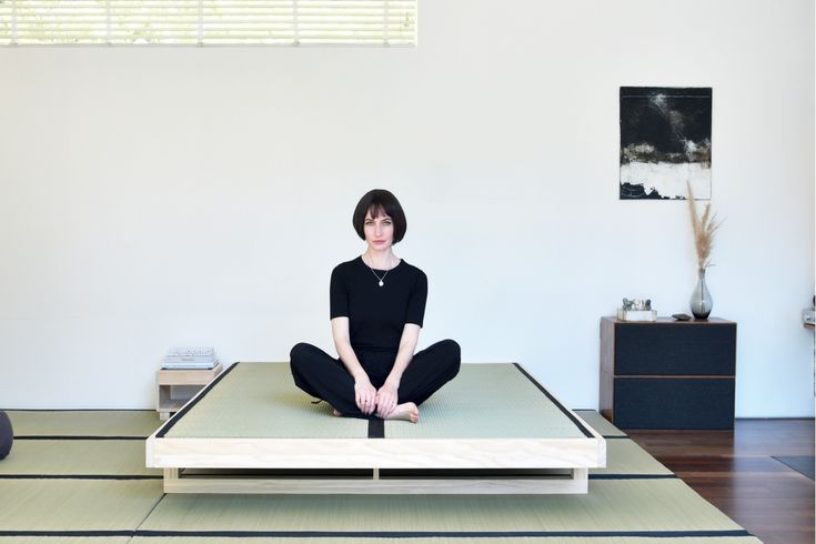 a woman is sitting in the middle of a yoga mat with her legs crossed and feet crossed