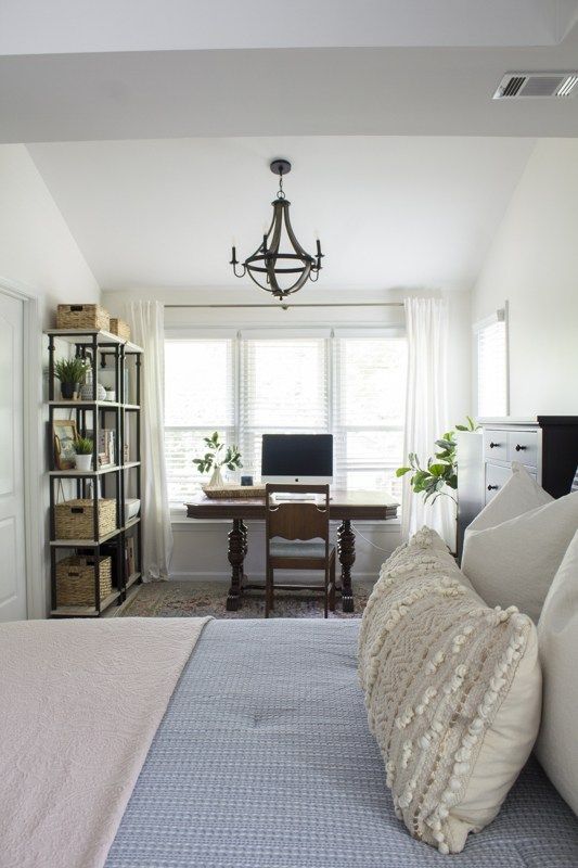 a bedroom with a bed, desk and window