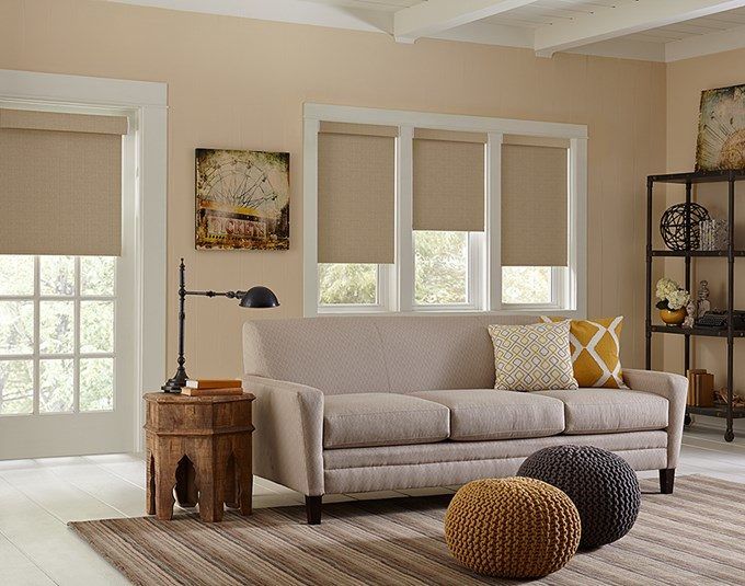 a living room filled with furniture and lots of window coverings on the windowsill