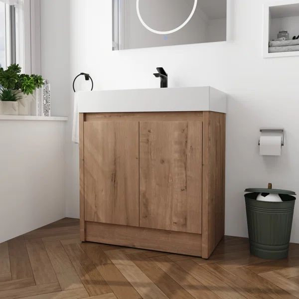 a bathroom with a sink, mirror and trash can