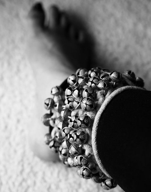 a black and white photo of a hat with skulls on the front, sitting on carpet