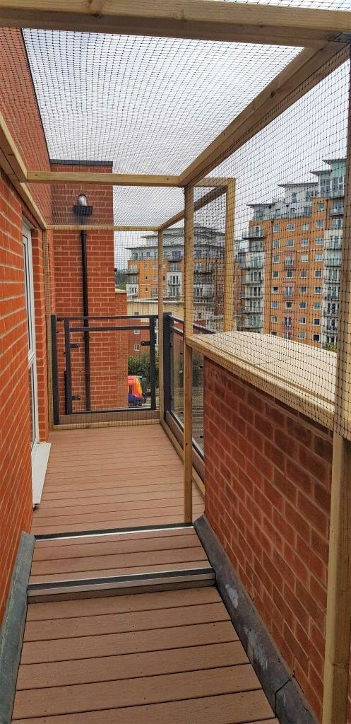 a wooden walkway between two brick buildings