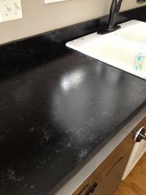 a black counter top next to a sink in a bathroom