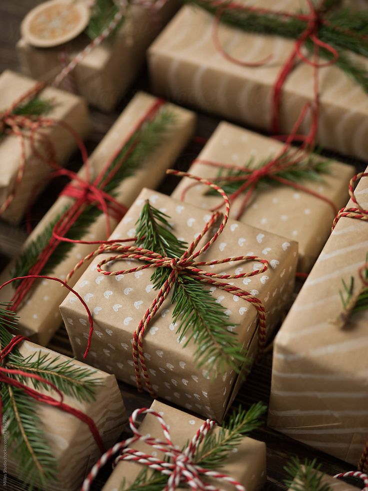 many wrapped presents with red and white bows on them are sitting on a table next to each other