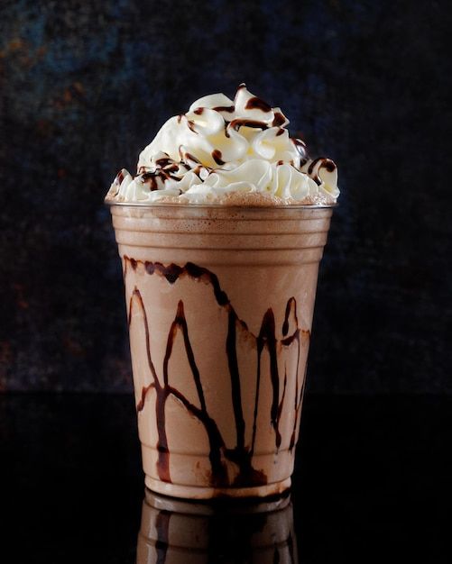 a cup filled with whipped cream and chocolate