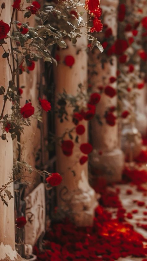 red rose petals are on the ground next to tall pillars with candles and vases