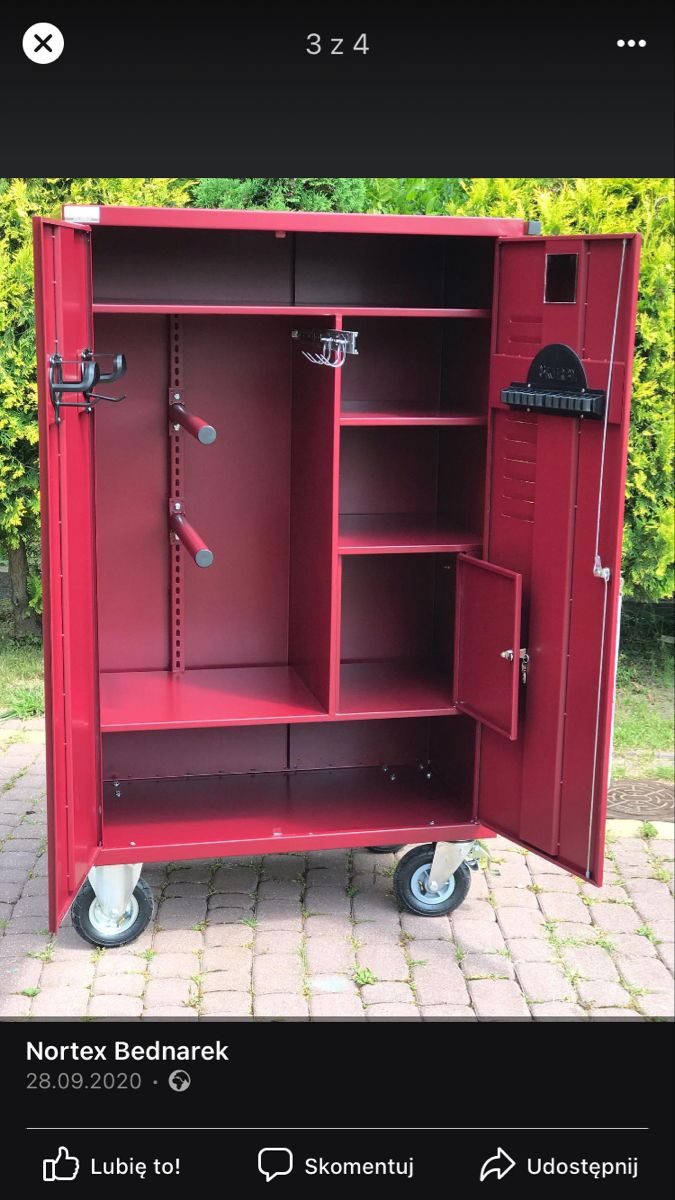 a red metal locker sitting on top of a brick floor