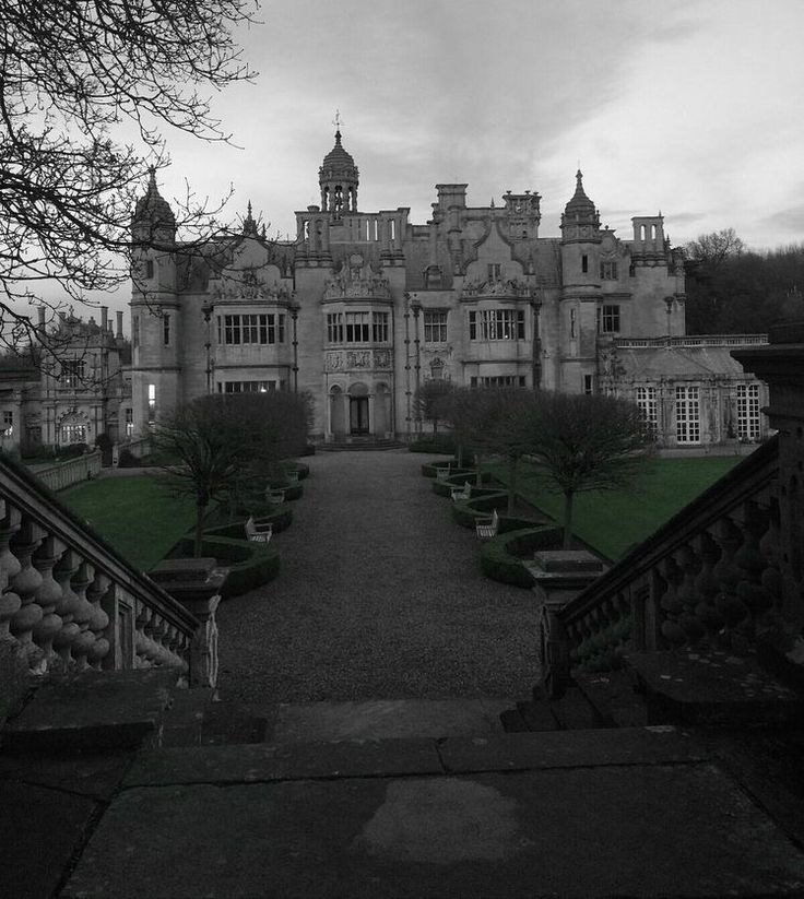 an old building with many windows and stairs leading to the front door, on a cloudy day