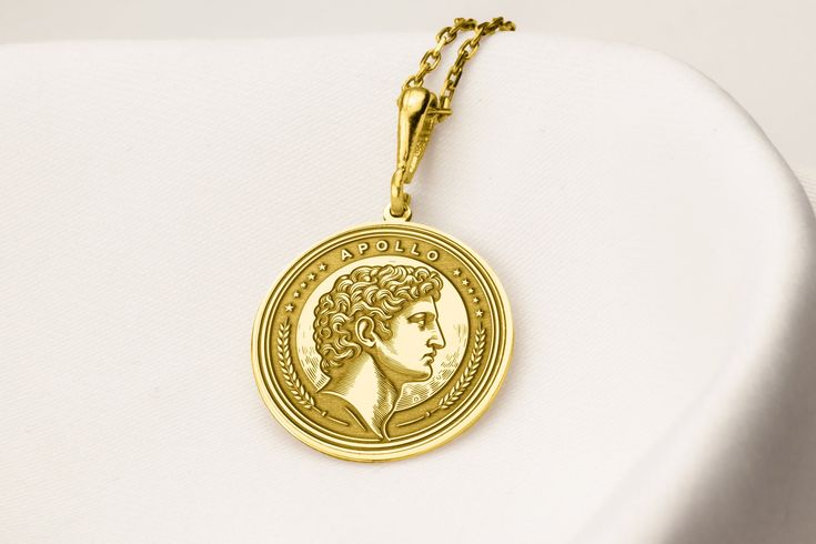 a gold necklace with a portrait of a young man on the front and back of it