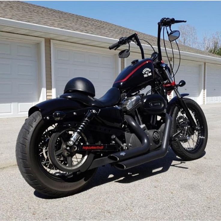 a black motorcycle parked in front of a garage