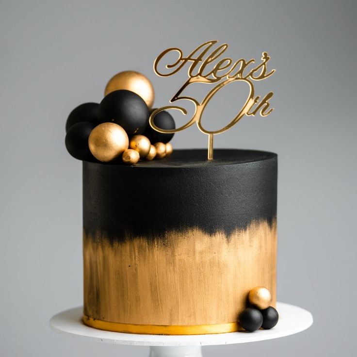 there is a black and gold cake on the table