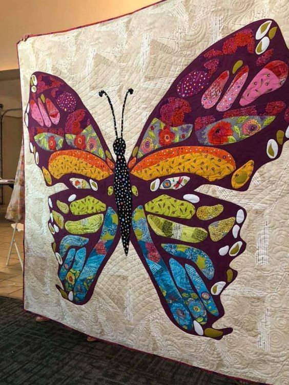 a large butterfly quilt hanging on the wall