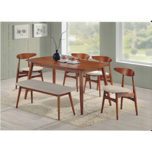 a dining room table with four chairs and a bench