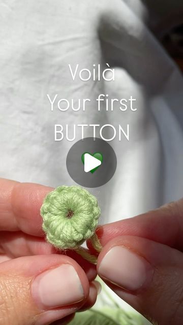 a person holding a tiny green flower in their hand with the words volta your first button below it