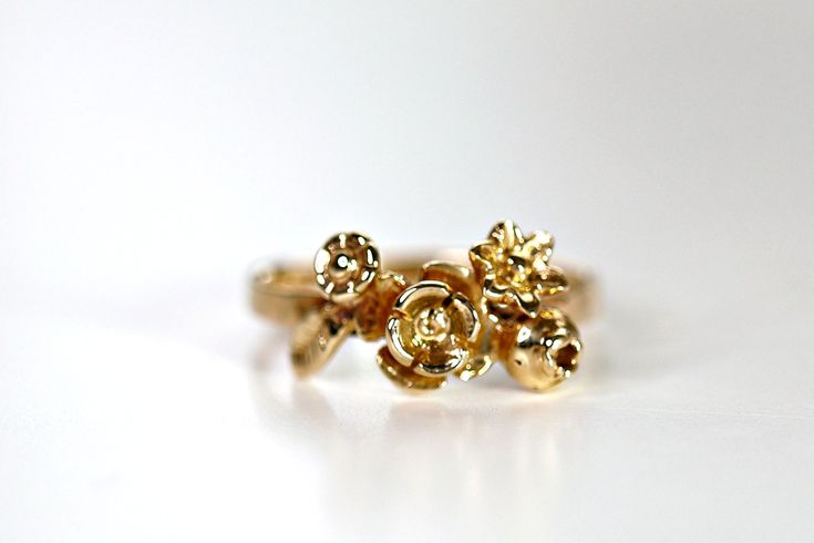 a gold ring with three flowers on it