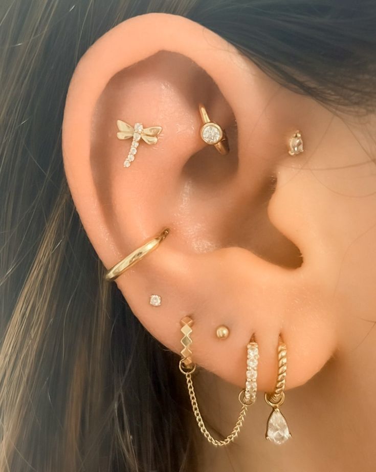 a woman's ear with three different types of piercings