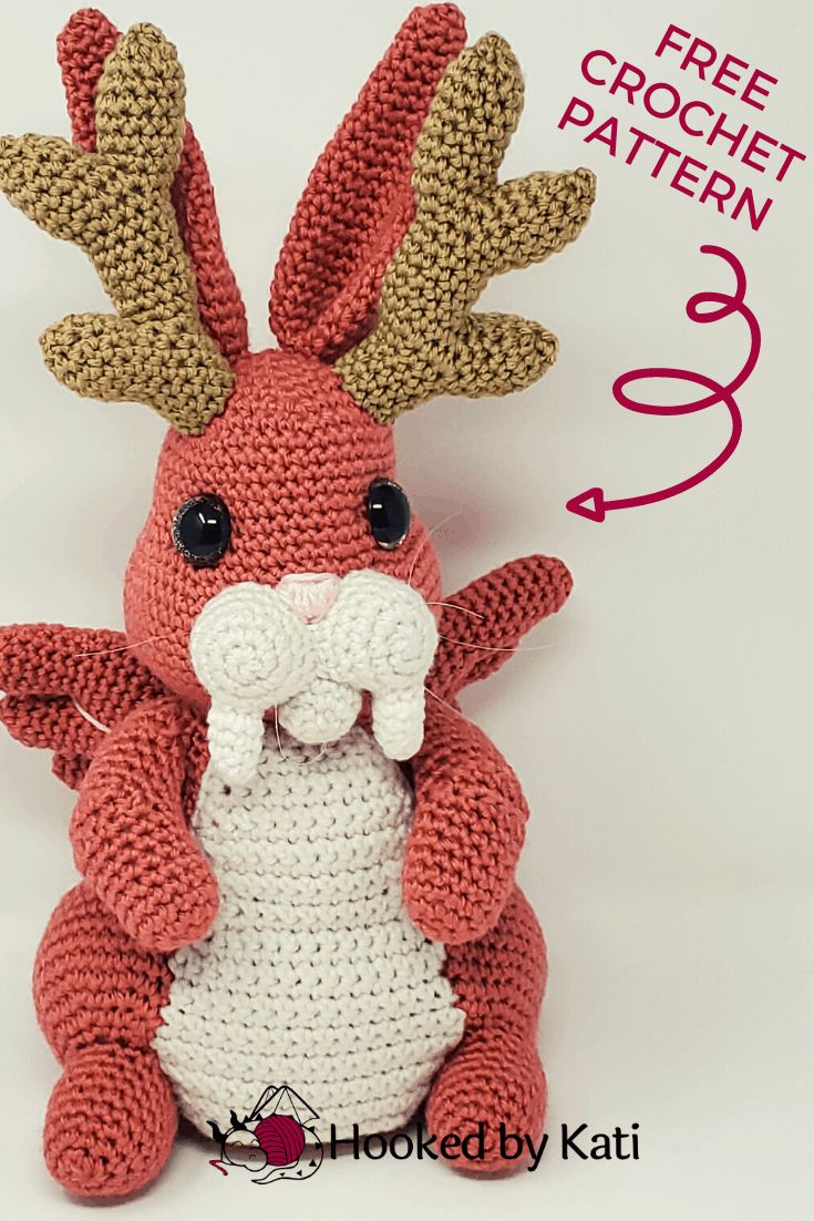 a crocheted red and white stuffed animal with antlers on it's head