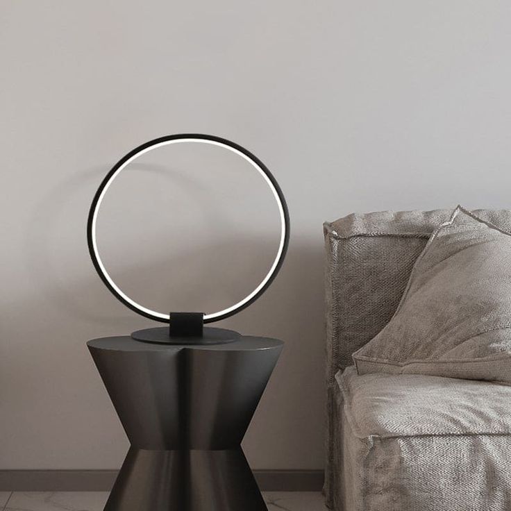 Introducing Nora, the epitome of modernism in lighting! This Annular Metal Table Lamp is designed to elevate your space with its sleek and contemporary aesthetic. Crafted from premium quality metal, its black finish adds a touch of elegance to any room. The lamp features an annular shape that emits a warm or white light, creating the perfect ambiance for relaxation or productivity. With its slim round pedestal, Nora seamlessly blends into any decor style, making it an ideal addition to your bedroom, living room, or office. Powered by energy-efficient LED technology, this lamp not only illuminates your space but also reduces your electricity consumption. Enhance your home or workspace with Nora, the modern table lamp that effortlessly combines style and functionality.Size: 16 to 17 Inch Len Electricity Consumption, Black Night, Metal Table Lamp, Warm White Light, Table Metal, Blackest Night, Metal Table Lamps, Contemporary Aesthetic, Modern Table Lamp