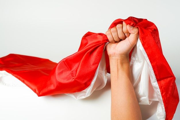 a person holding up a red and white scarf