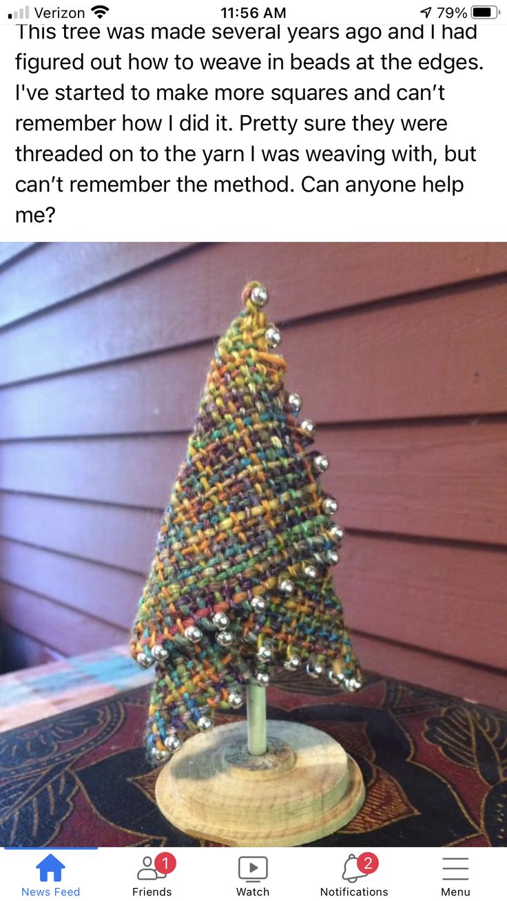 a christmas tree made out of beads on top of a wooden table next to a house