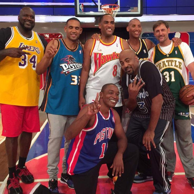 a group of men standing next to each other on a basketball court