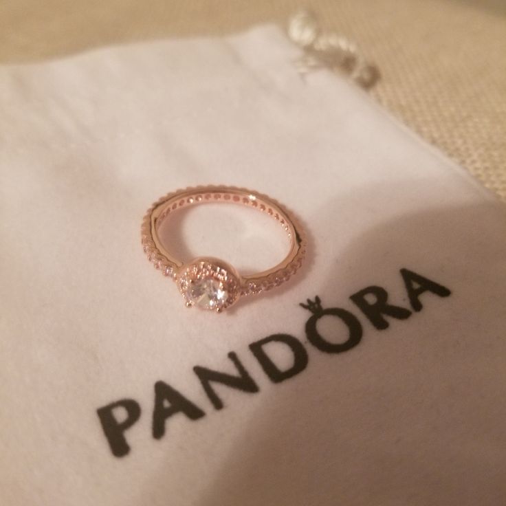 a pink gold ring sitting on top of a white napkin with the word pandara written across it