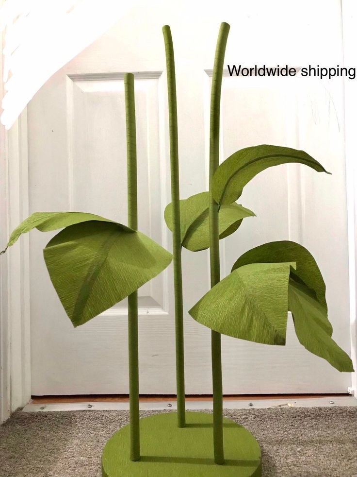 two large green plants are in front of a white door