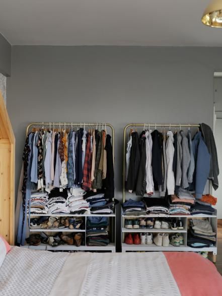 an organized bedroom with clothes and shoes on racks