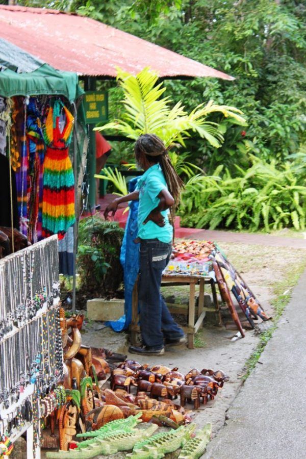 a woman standing in front of a store selling necklaces and bracelets on display